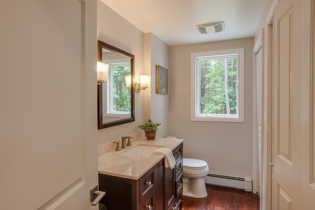 40 Tenney Road Rowley, MA 01969 - Photo 13 of 28 a bathroom with a toilet a sink a mirror and a window