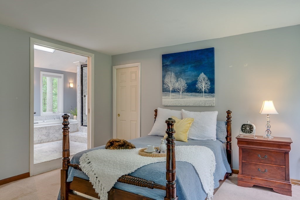 40 Tenney Road Rowley, MA 01969 - Photo 15 of 28 a bedroom with a bed and a chandelier