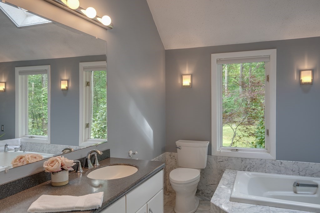 40 Tenney Road Rowley, MA 01969 - Photo 17 of 28 a bathroom with a granite countertop sink toilet a large mirror a window and shower