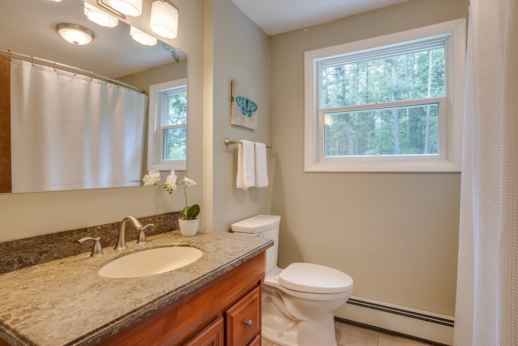40 Tenney Road Rowley, MA 01969 - Photo 19 of 28 a bathroom with a granite countertop sink toilet and a mirror
