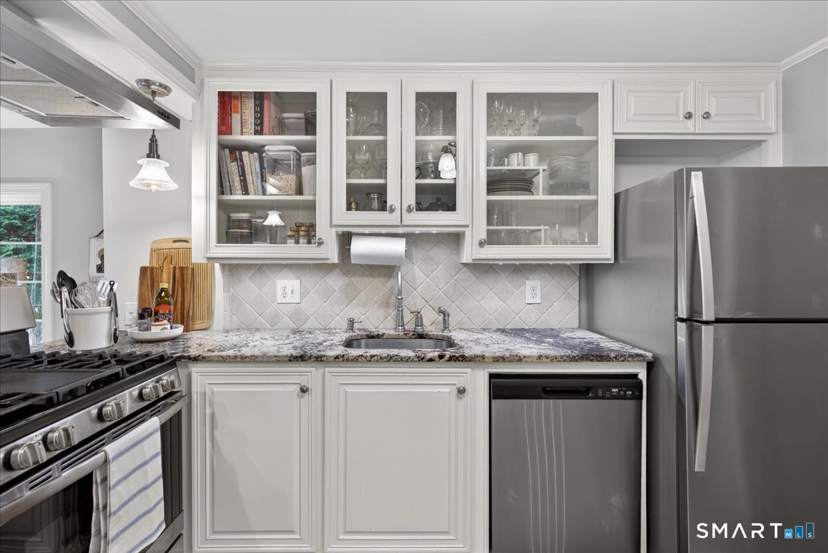 54 Jackson Road Hamden, CT 06517 - Photo 11 of 40 a kitchen with stainless steel appliances granite countertop a refrigerator a sink and white cabinets