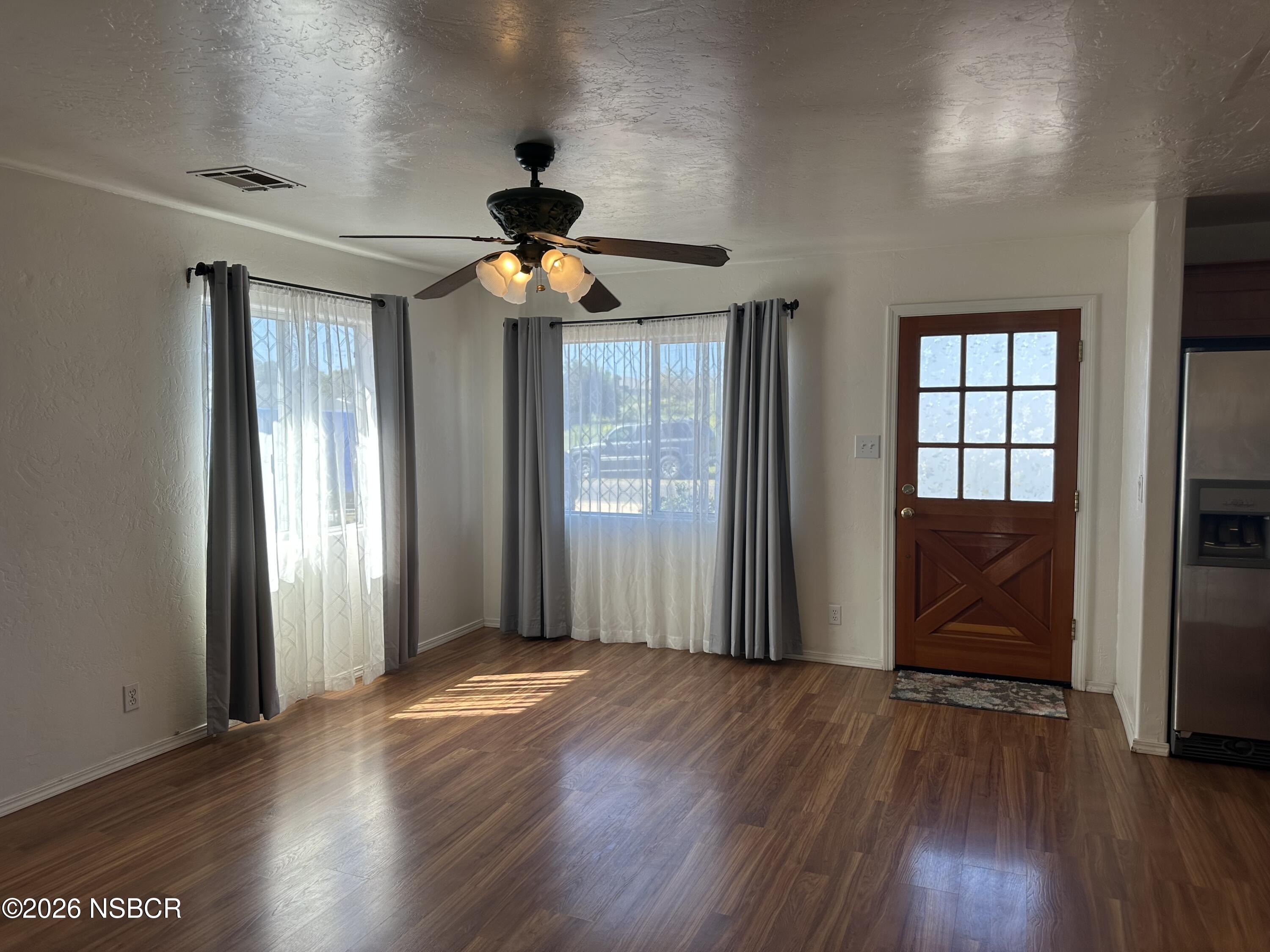 192 East Branch Street Nipomo, CA 93444 - Photo 13 of 26 a view of a livingroom with wooden floor and a ceiling fan