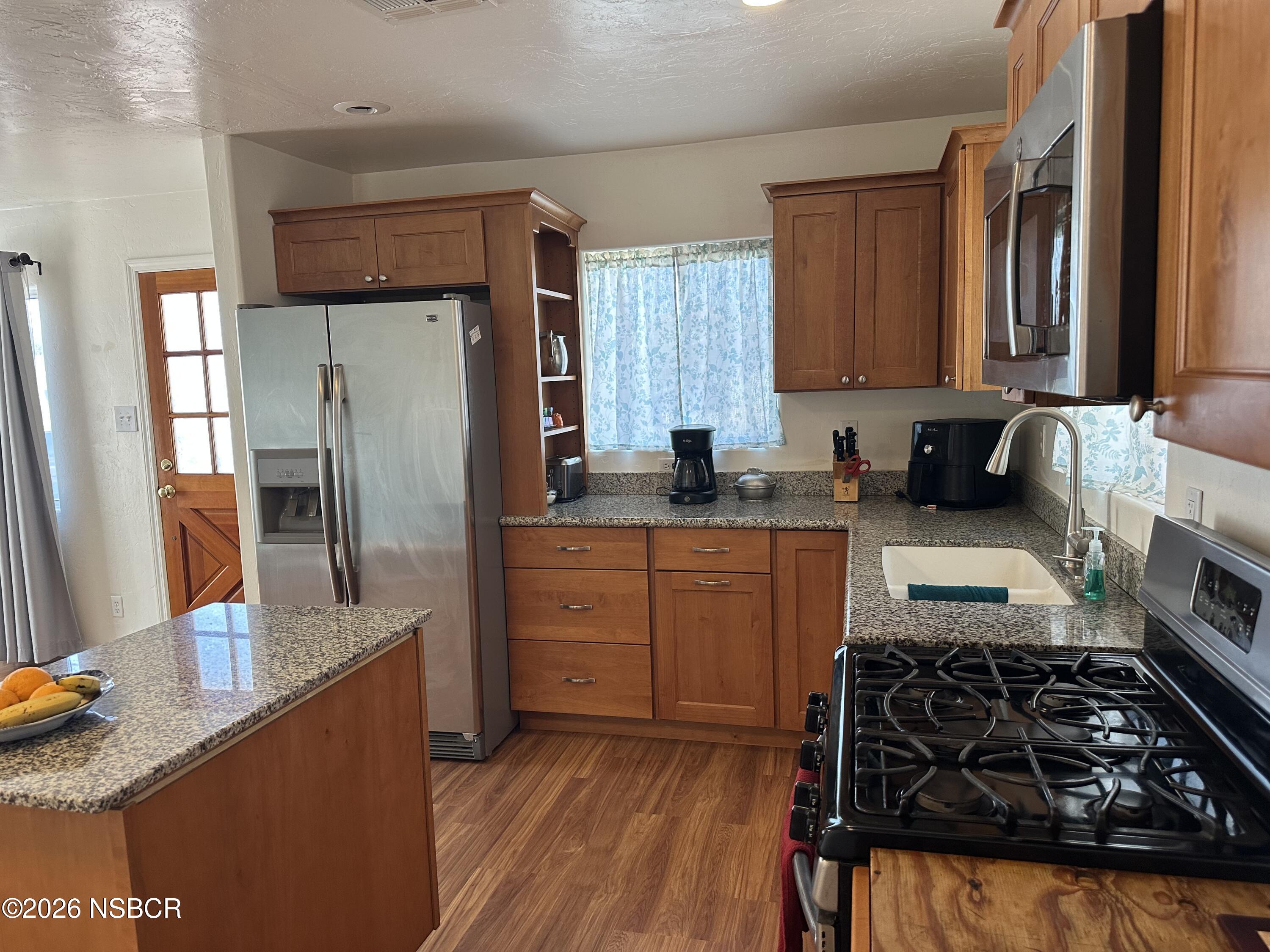 192 East Branch Street Nipomo, CA 93444 - Photo 8 of 26 a kitchen with granite countertop a sink stove and refrigerator