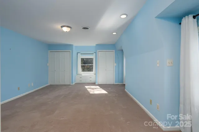 an empty room with windows and closet