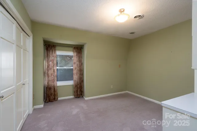 an empty room with closet and windows