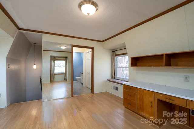 a view of a hallway with wooden floor and staircase