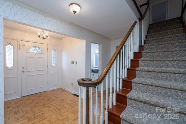 a view of staircase with wooden floor and a chandelier