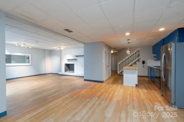 a view of empty room with wooden floor and fireplace