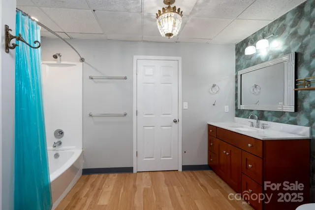 a bathroom with a granite countertop sink a mirror a vanity and a shower