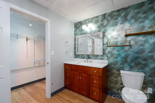 a bathroom with a granite countertop toilet sink and mirror