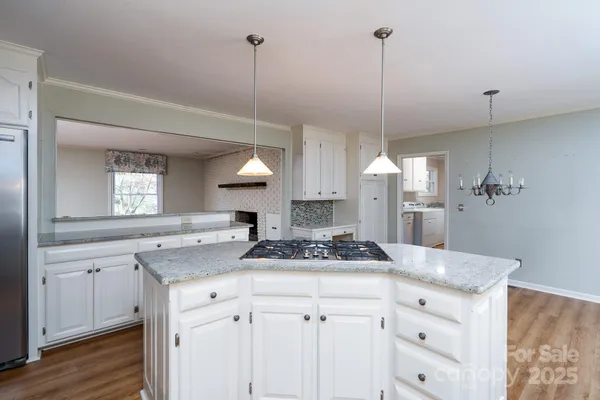 a kitchen with appliances cabinets and a wooden floor