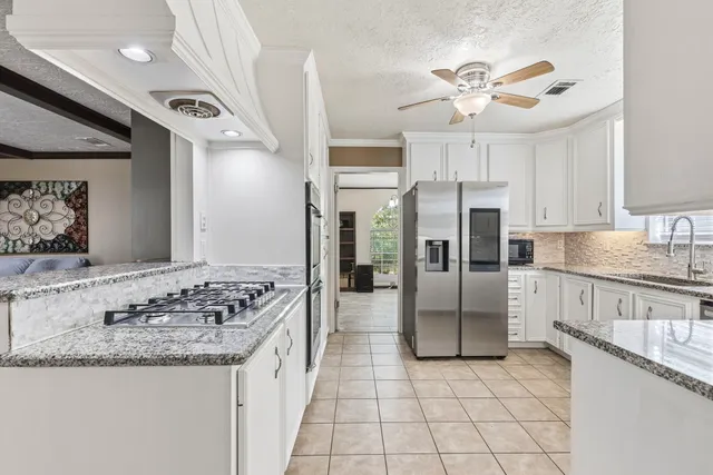 a kitchen with stainless steel appliances granite countertop a sink stove and refrigerator