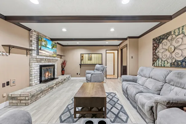 a living room with furniture a fireplace and a large window