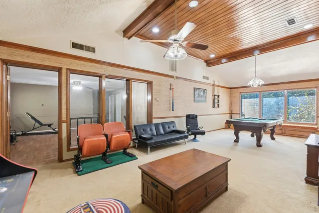 a living room with furniture a ceiling fan and a large window