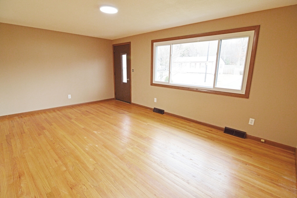 122 Garnet Street Springfield, MA 01129 - Photo 2 of 36 a view of an empty room with wooden floor and a window