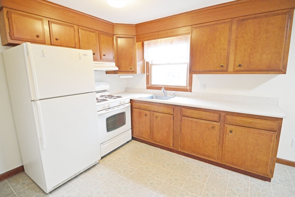 122 Garnet Street Springfield, MA 01129 - Photo 6 of 36 a white refrigerator freezer sitting inside of a kitchen