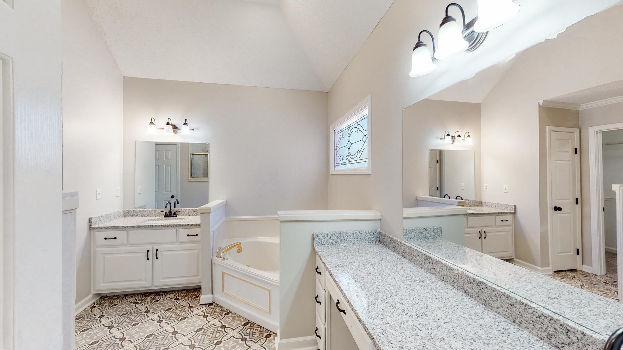 8629 Brunswick Road Millington, TN 38053 - Photo 12 of 25 a large bathroom with a granite countertop double vanity sink a mirror and a bathtub