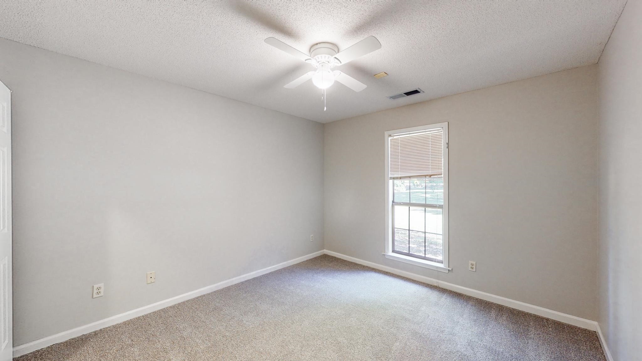 8629 Brunswick Road Millington, TN 38053 - Photo 16 of 25 an empty room with windows and chandelier fan