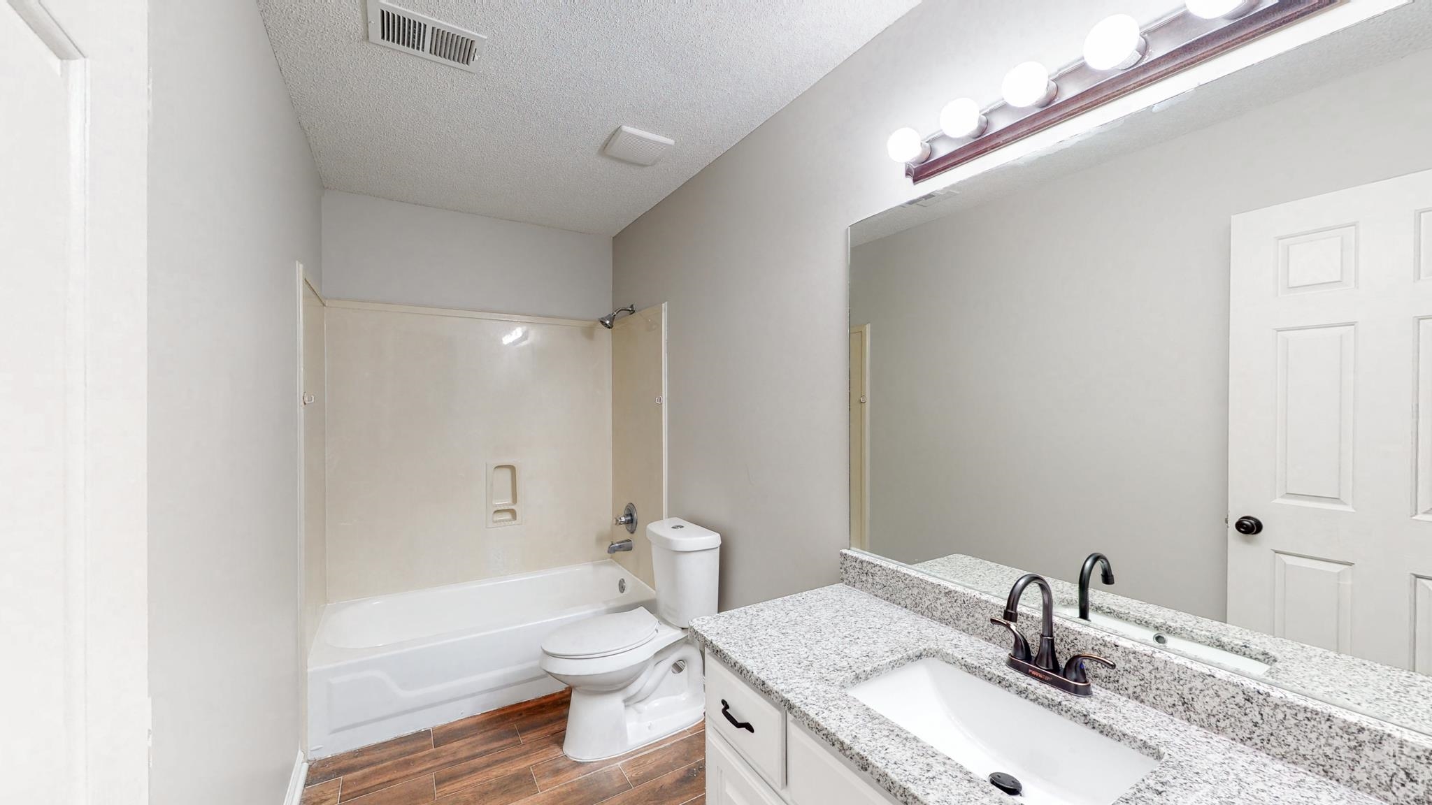 8629 Brunswick Road Millington, TN 38053 - Photo 17 of 25 a bathroom with a granite countertop sink a toilet and shower