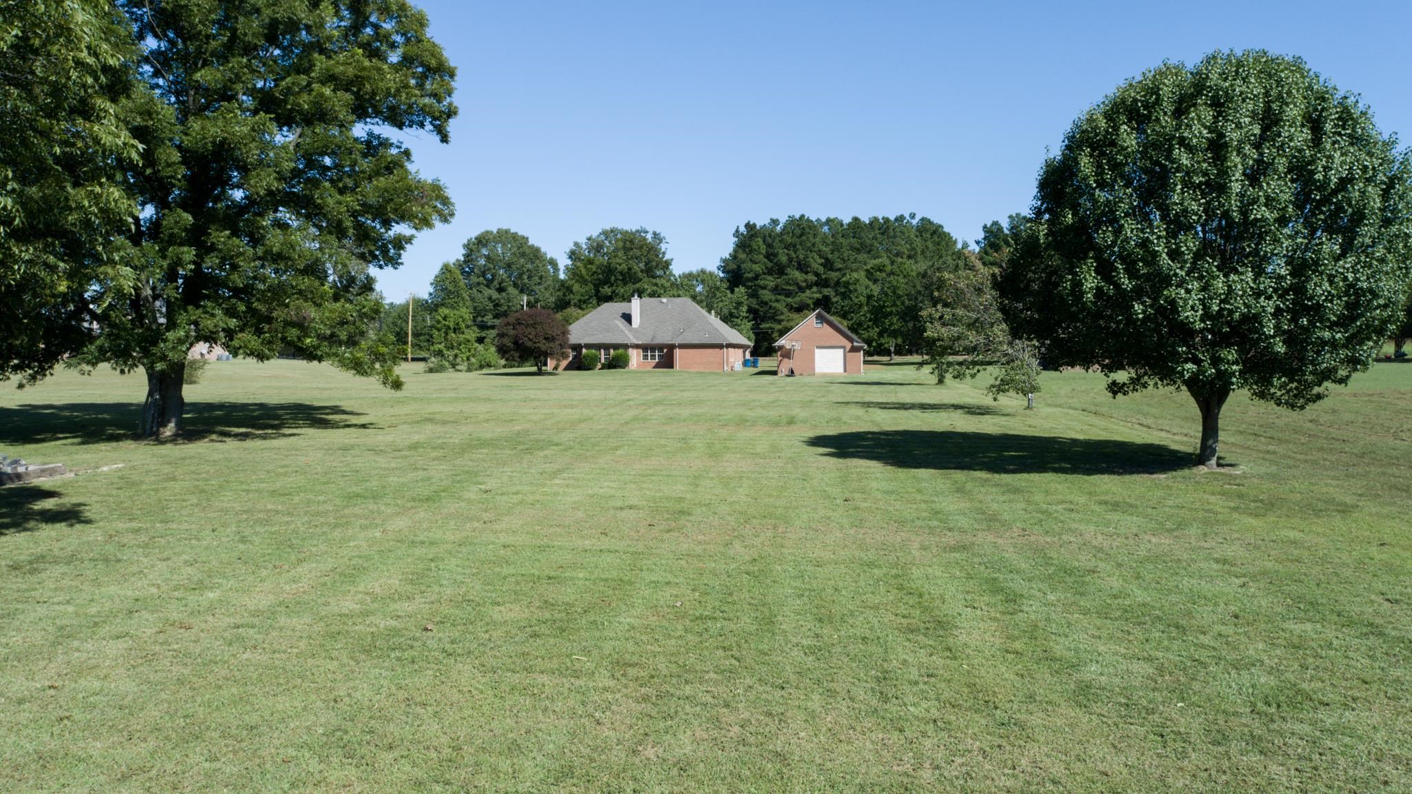 8629 Brunswick Road Millington, TN 38053 - Photo 20 of 25 a backyard of a house with a yard and outdoor seating