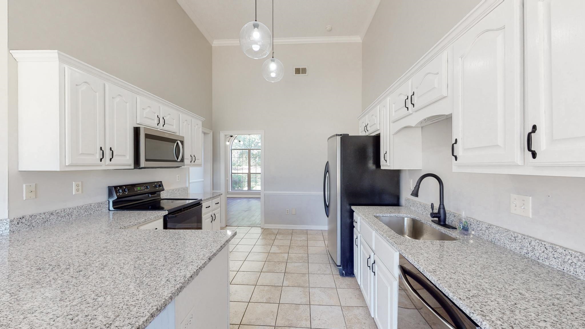 8629 Brunswick Road Millington, TN 38053 - Photo 10 of 25 a kitchen with stainless steel appliances granite countertop a sink stove and refrigerator