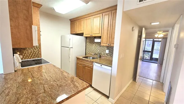 a kitchen with a refrigerator and a stove top oven