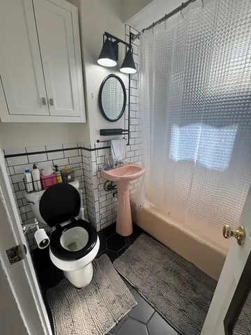 a bathroom with a toilet and a mirror