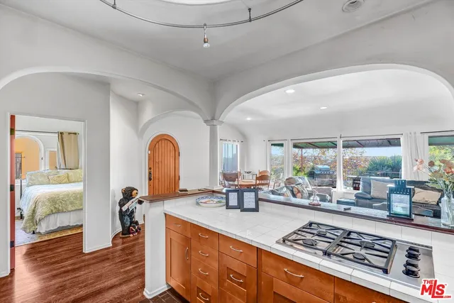 a kitchen with stainless steel appliances a stove a sink dishwasher and cabinets with wooden floor