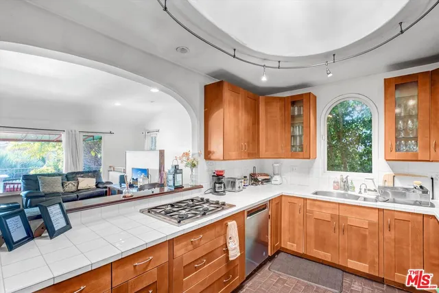 a kitchen with stainless steel appliances granite countertop a sink stove and cabinets