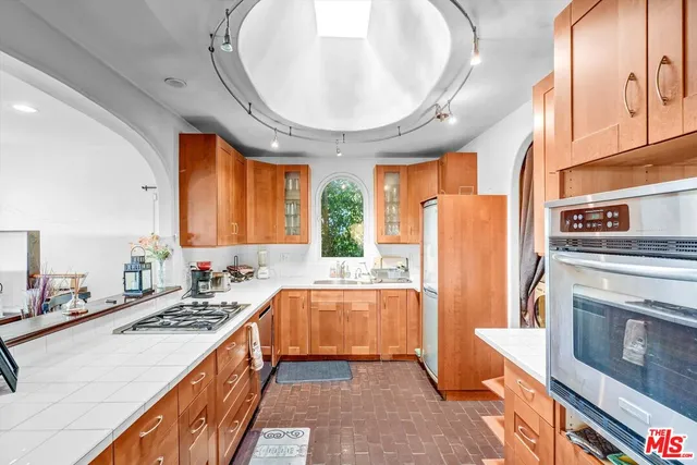 a kitchen with stainless steel appliances a stove a refrigerator and a sink