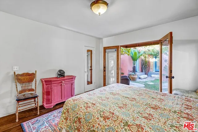 a bedroom with a bed and large windows