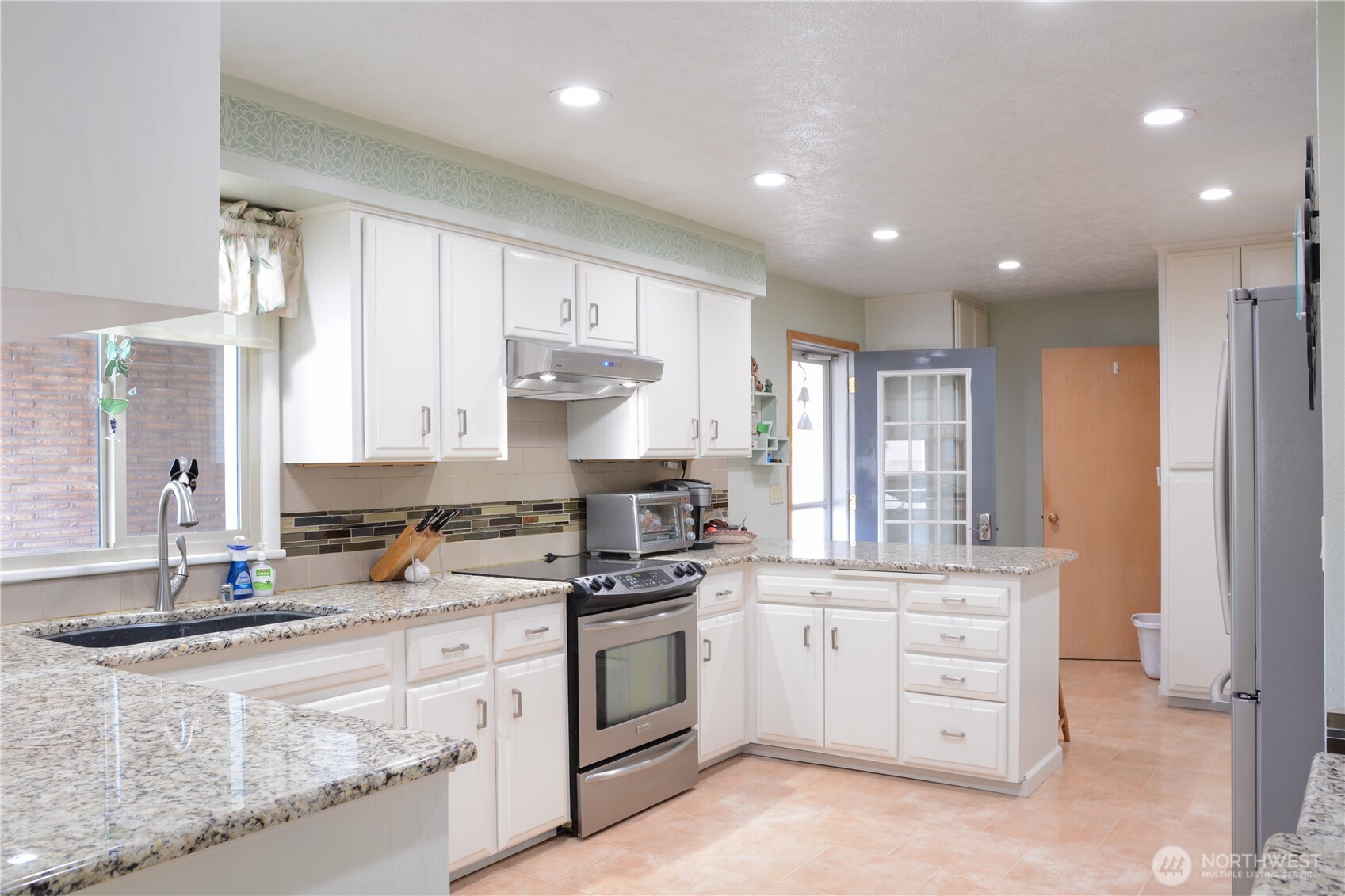 310 West 9th Avenue Ritzville, WA 99169 - Photo 7 of 38 a kitchen with a stove a sink and a refrigerator