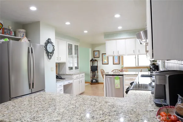 a kitchen with stainless steel appliances granite countertop a refrigerator stove top oven and sink