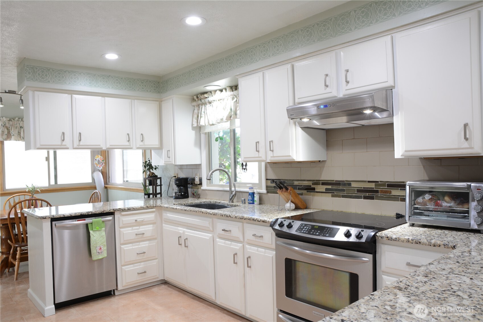 310 West 9th Avenue Ritzville, WA 99169 - Photo 9 of 38 a kitchen with stainless steel appliances granite countertop a stove a sink and white cabinets