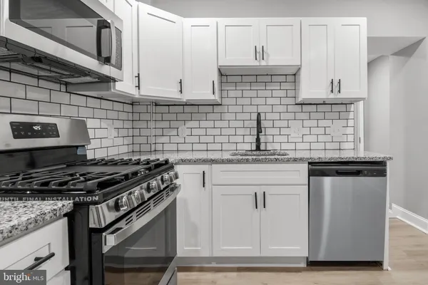 a kitchen with stainless steel appliances granite countertop a sink stove and cabinets