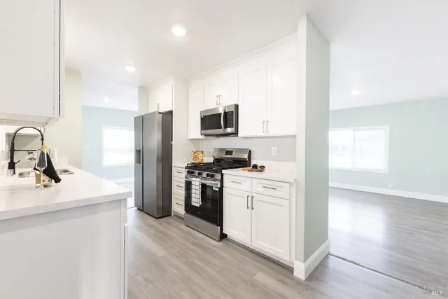 a kitchen with stainless steel appliances a sink stove refrigerator and cabinets