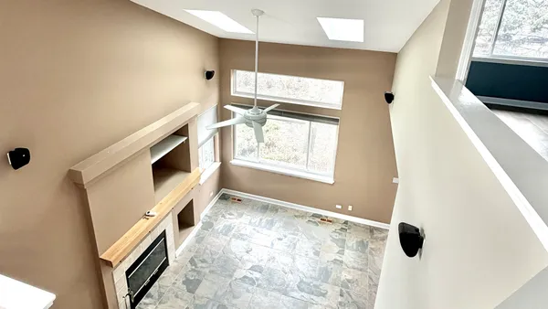 a view of an empty room with a fireplace and a window