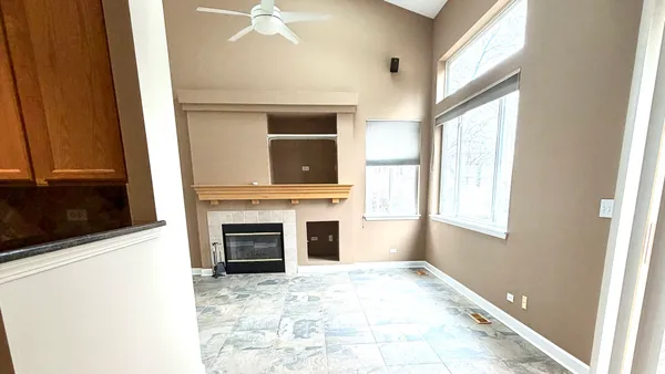 a view of a hallway with wooden floor and a bathroom
