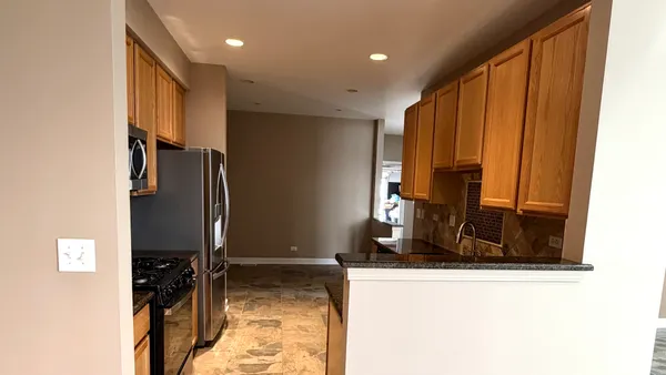 a view of a hallway with wooden floor and a living room