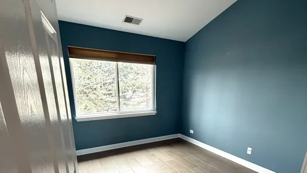 an empty room with wooden floor and entrance