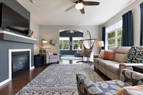 a living room with furniture a flat screen tv and a fireplace