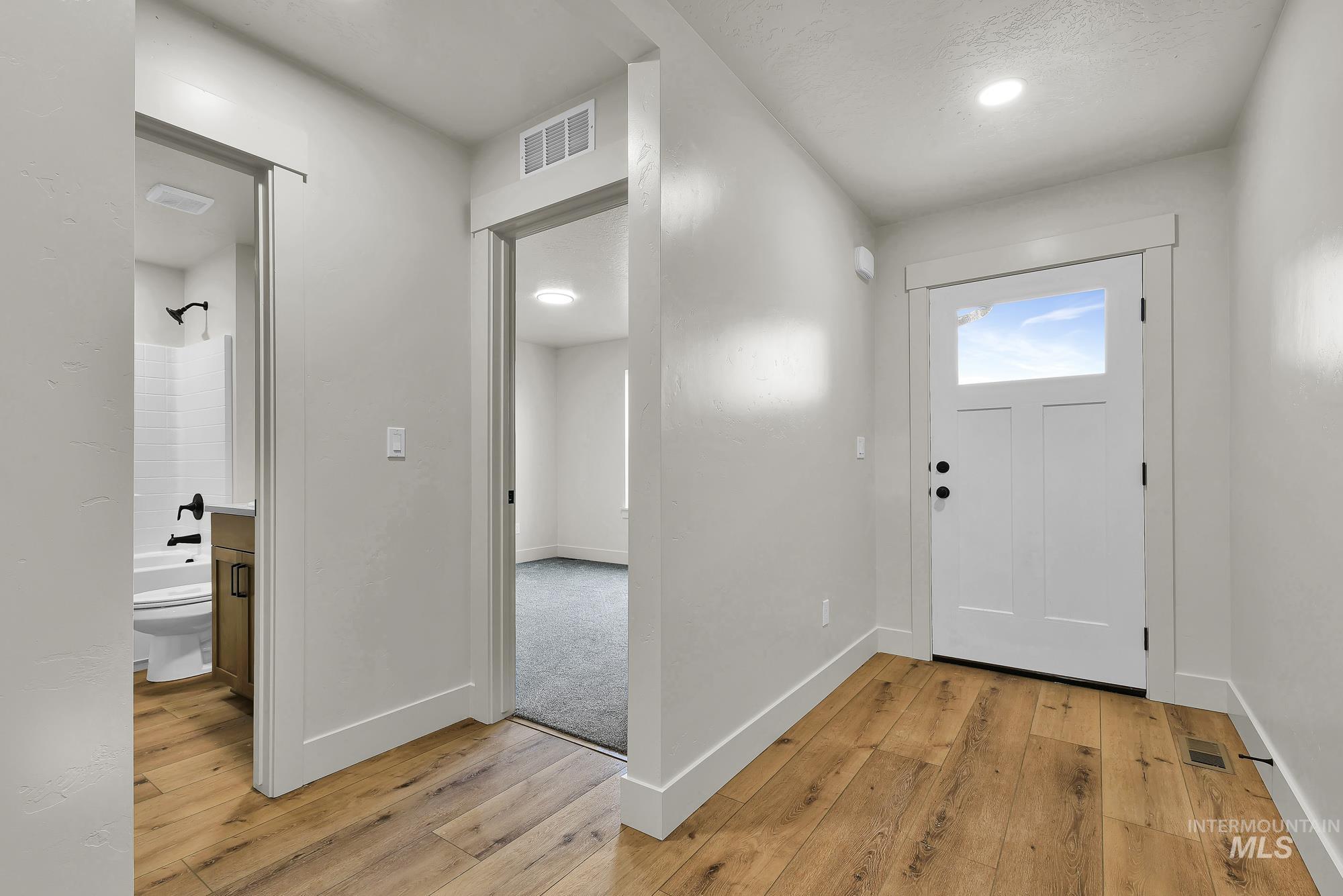 1130 Velvet Loop Wilder, ID 83676 - Photo 26 of 35 Entryway featuring wood-finish flooring, a white paneled door with an upper glass insert, and recessed lighting