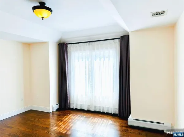an empty room with a window and wooden floor