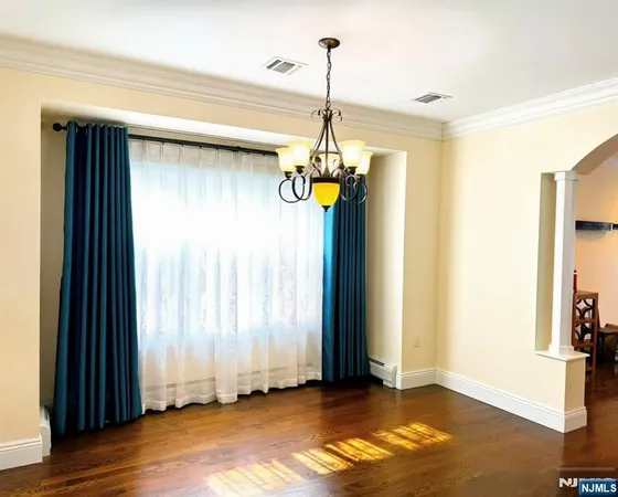 a view of a hallway with windows and chandelier