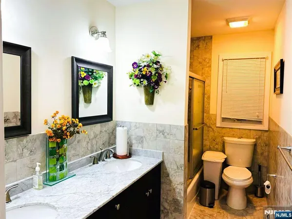 a bathroom with a granite countertop toilet sink and mirror