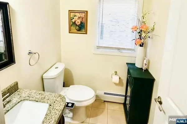 a bathroom with a granite countertop toilet sink and mirror