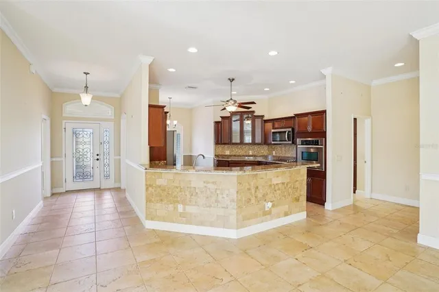 a large kitchen with stainless steel appliances kitchen island granite countertop a refrigerator and a stove top oven