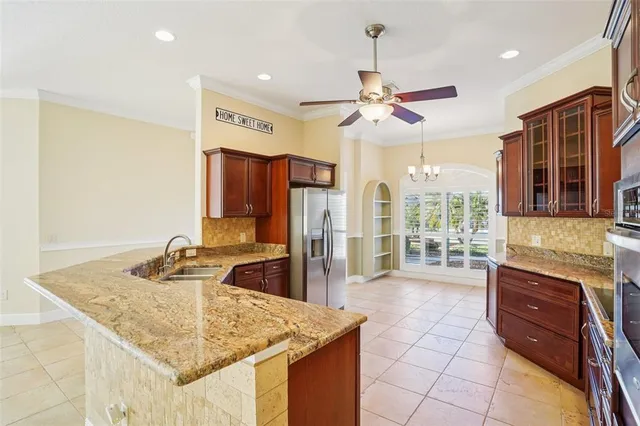 a kitchen with stainless steel appliances granite countertop a sink and a refrigerator