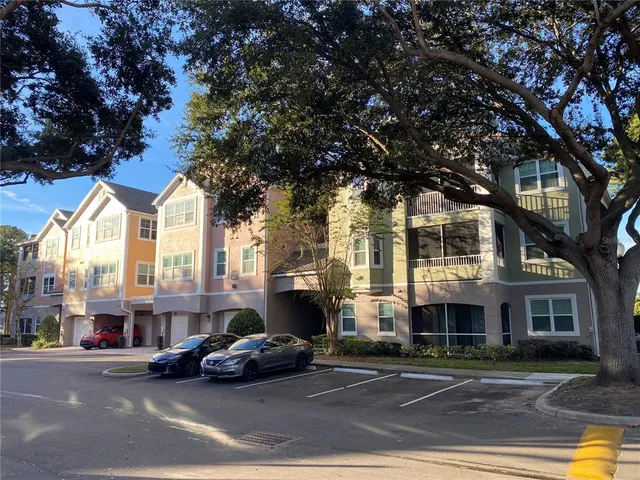 a front view of a building with cars parked