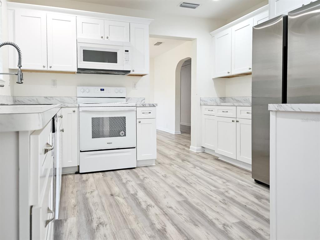 518 Northwest 27th Avenue Gainesville, FL 32609 - Photo 11 of 34 a kitchen with stainless steel appliances a stove microwave and refrigerator